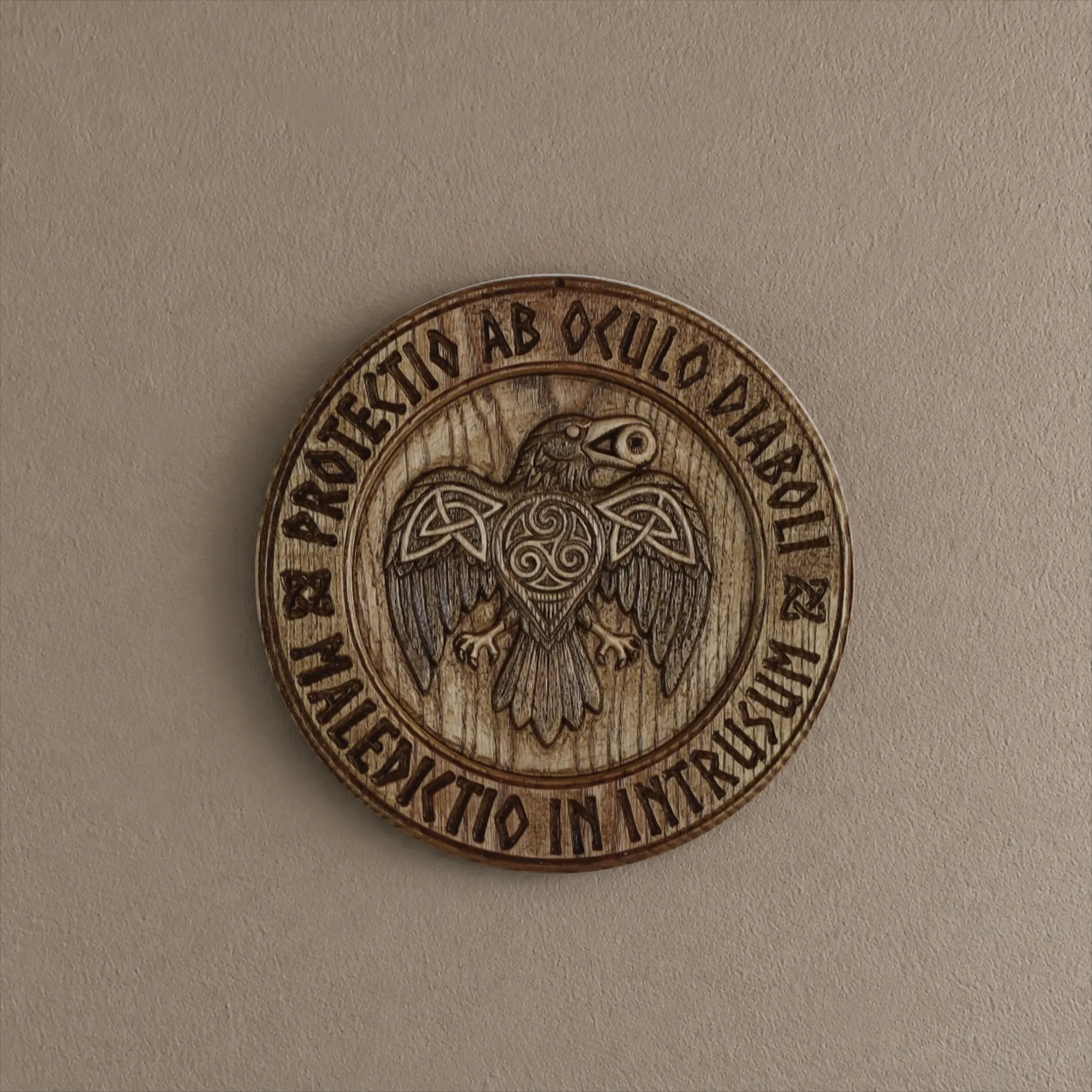 Raven Warden I mounted on a wall, showing the circular carved relief and Latin inscription